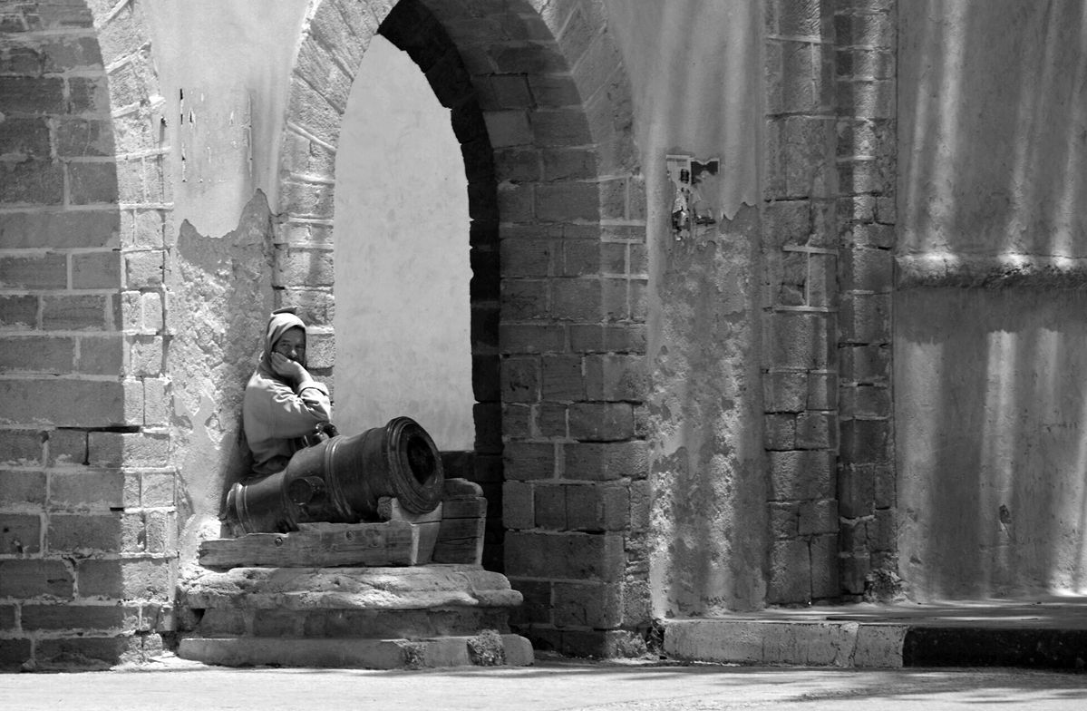 Man zit bij stadsmuur in Essaouira/Marokko