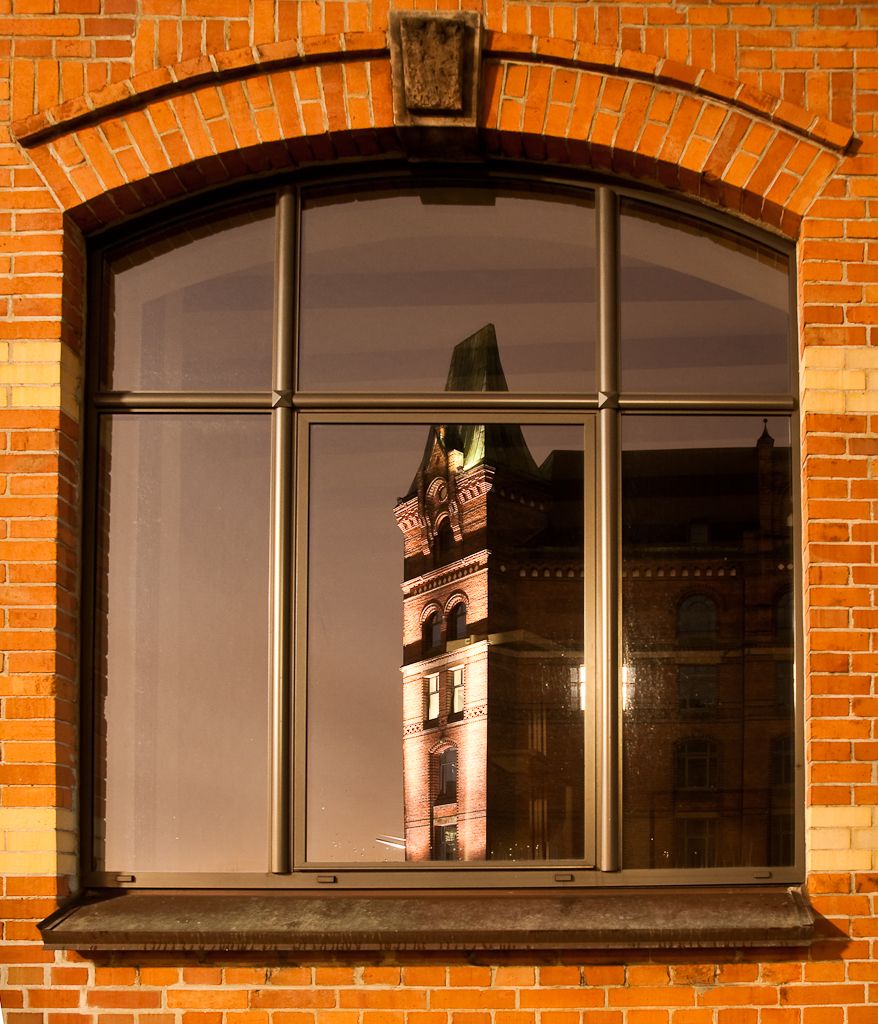 Bild von der Tour mit den Anderen durch die Speicherstadt. Das erleuchtete Fenster im gespiegelten Gebäude mit der Strebe "getötet".  Bild schräg aufgenommen und anschließend in Photoshop begradigt.